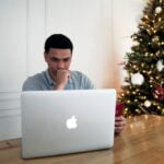 man in gray crew neck shirt sitting in front of silver macbook