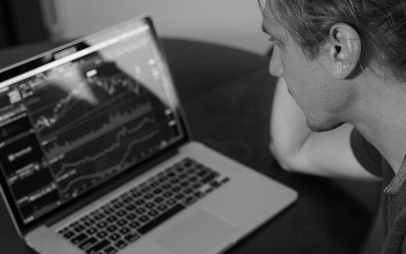 grayscale photo of man looking at macbook pro