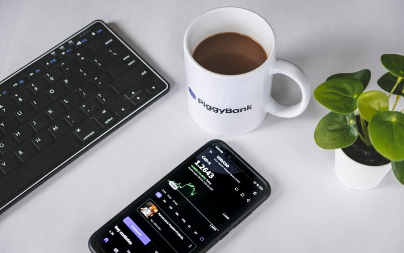 a cell phone sitting next to a cup of coffee