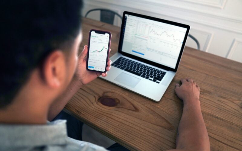 person holding iphone 6 near macbook pro