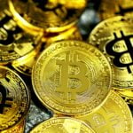 a pile of gold bitcoins sitting next to each other