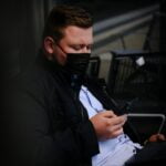 a man sitting on a bench looking at his cell phone