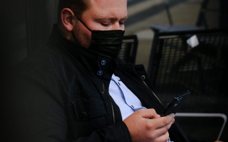 a man sitting on a bench looking at his cell phone