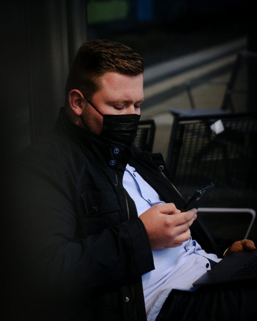 a man sitting on a bench looking at his cell phone